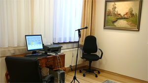 Untersuchungsraum mit Holztisch, PC und Mikrofon